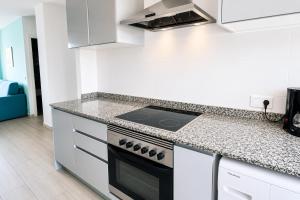 a kitchen with white cabinets and a stove top oven at Turyva Tarongers 1 - Modern 1-Bedroom Apartment Near the Beach, Costa del Azahar in Peniscola +12 photos