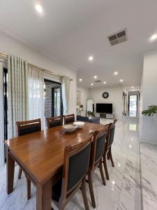 a dining room with a wooden table and chairs at Matthews Green fall House in Sunshine