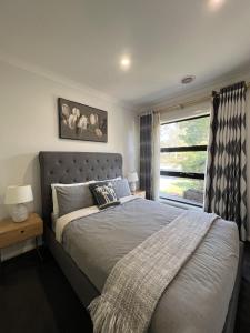 a bedroom with a large bed and a window at Matthews Green fall House in Sunshine