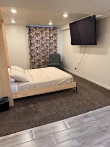 a bedroom with a bed and a flat screen tv at Green Clover Hideaway in Draper