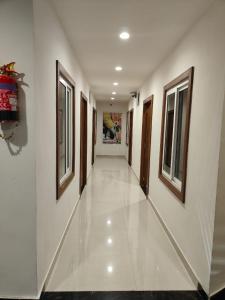 a hallway with white walls and windows in a building at Hotel Shree Krishnam, Kota in Kota