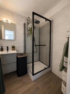 a shower with a glass door in a bathroom at Maison Plumeria in Triel-sur-Seine