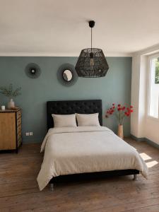 a bedroom with a large bed and a pendant light at Maison Plumeria in Triel-sur-Seine