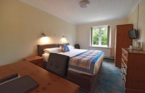 a hotel room with a bed and a desk and a table at Marton Guest House in St. Peter Port +19 photos