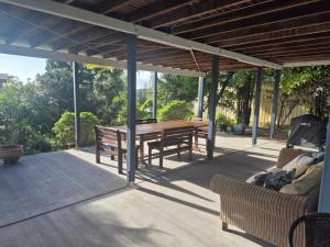 a patio with a wooden table and benches on a deck at Rainbow Heights 2 Bed Apartment in Rainbow Beach