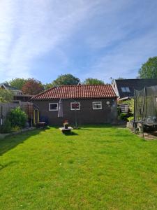 a yard with a small house with a green lawn at Drenthse Klaver in Borger in Borger