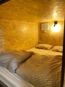 a bedroom with two beds in a stone wall at Guest House SOL in Hiraisomachi