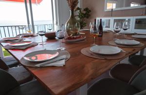 a wooden table with plates and wine glasses on it at La Marisol Ribeira in Ribeira +18 photos