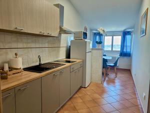 a kitchen with a sink and a refrigerator and a table at La Casa di Stefy - affittacamere in Cammarata