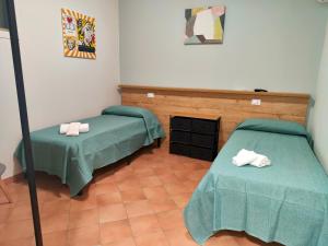 a room with two green beds and a mirror at La Casa di Stefy - affittacamere in Cammarata