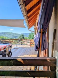 a patio with an umbrella on a wooden deck at Gîte FRAIZE in Fraize