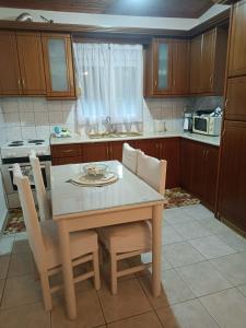 a kitchen with a table and chairs and a table and a microwave at Alexia's House in Leptokarya
