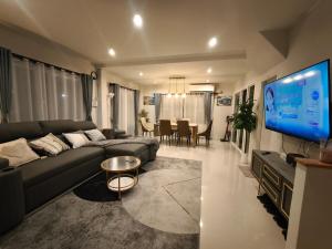 a living room with a couch and a flat screen tv at Silbergluuk in Udon Thani