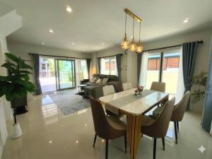 a living room with a table and chairs and a couch at Silbergluuk in Udon Thani