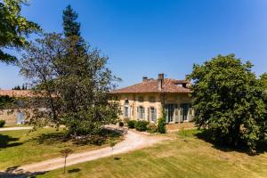 an old house with a tree in the yard at Château Puybarban in Puybarban