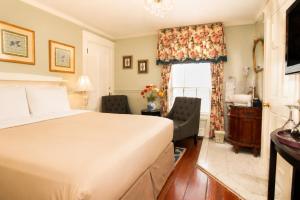 a bedroom with a bed and a sink and a window at Inn on Bellevue in Newport