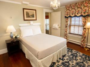 a bedroom with a large bed and a chandelier at Inn on Bellevue in Newport