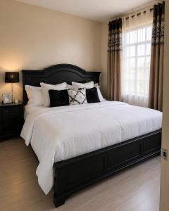 a bedroom with a large bed with white sheets and pillows at One bedroom in Narok