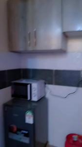 a microwave sitting on top of a counter in a kitchen at One bedroom in Narok