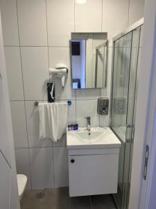 a white bathroom with a sink and a shower at Mudanya Yıldız Otel in Mudanya