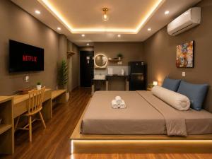 a bedroom with a bed and a kitchen and a desk at Ben Thanh Hideaway - A Cozi Stay in Ho Chi Minh City