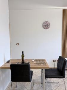 a table with two chairs and a bottle of wine on it at Jacuzzi Central Apartment in Shkodër +14 photos