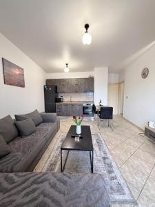 a living room with a couch and a table at Jacuzzi Central Apartment in Shkodër