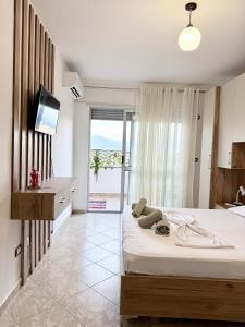 a bedroom with a bed with a teddy bear on it at Jacuzzi Central Apartment in Shkodër