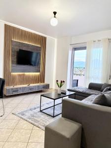 a living room with a couch and a tv at Jacuzzi Central Apartment in Shkodër