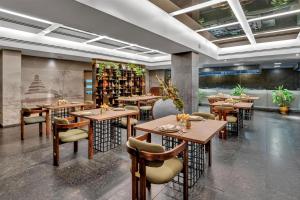 a restaurant with tables and chairs in a room at Radisson Blu Atria Bengaluru in Bangalore