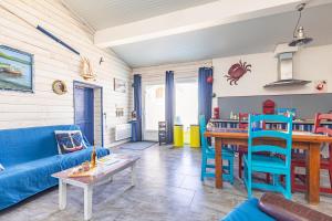 a living room with a blue couch and a table at Petite Maison Typique in La Cotinière +16 photos