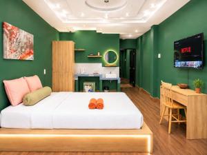 a bedroom with a bed and a desk with a television at Ben Thanh Hideaway - A Cozi Stay in Ho Chi Minh City