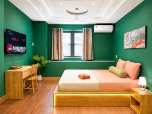 a green bedroom with a bed and a desk at Ben Thanh Hideaway - A Cozi Stay in Ho Chi Minh City