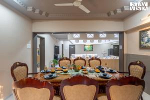 a dining room with a table and chairs at Hindavi Green Escape by VEO - Part of StayVista with Bonfire, BBQ & Pool in Pune