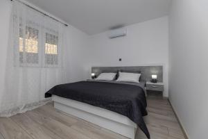 a white bedroom with a bed and a window at Apartman Klara in Vrgorac +19 photos