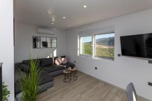 a living room with a black couch and a flat screen tv at Apartman Klara in Vrgorac