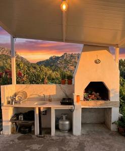 a kitchen with a pizza oven with a sunset in the background at Enjoy the Silence in Marmaris