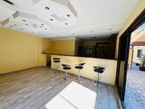 a bar with stools in a room with yellow walls at Otam-Check Guest House in Ondangwa +5 photos