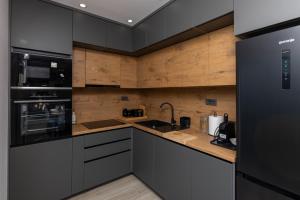 a kitchen with black appliances and wooden walls at Apartman Klara in Vrgorac