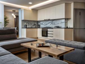 a living room with a table and a kitchen at Jasemina Luxury Apartment in Agios Nikolaos