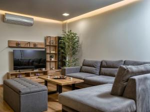 a living room with two couches and a television at Jasemina Luxury Apartment in Agios Nikolaos