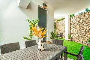 a vase sitting on a wooden table in a yard at Jasemina Luxury Apartment in Agios Nikolaos