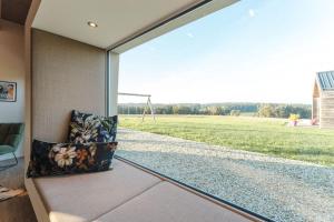 a room with a large window looking out at a field at Ferienhaus Rabenbrunn in Arnstorf +16 photos