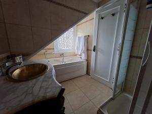 a bathroom with a sink and a shower and a tub at The Nile Dahabiya Lodge in Luxor