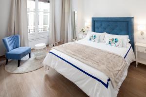1 dormitorio con 1 cama grande y cabecero azul en INMálaga Uncibay, en Málaga