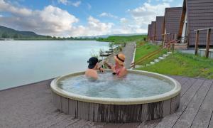 two men in a hot tub next to a body of water at Lagos Lac de Pescuit in Boiştea-Boerească +28 photos