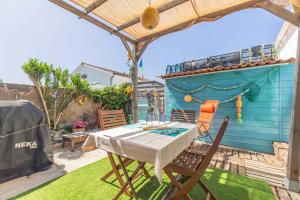 a patio with a table and chairs and a blue building at Petite Maison Typique in La Cotinière