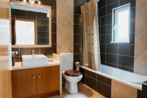 a bathroom with a toilet and a sink and a mirror at Aldeia Caiçara Surf Lodge - Arrifana in Aljezur