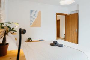 a bedroom with a bed with a pair of shoes on it at Aldeia Caiçara Surf Lodge - Arrifana in Aljezur