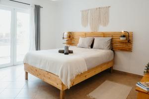 a bedroom with a bed with a wooden headboard at Aldeia Caiçara Surf Lodge - Arrifana in Aljezur